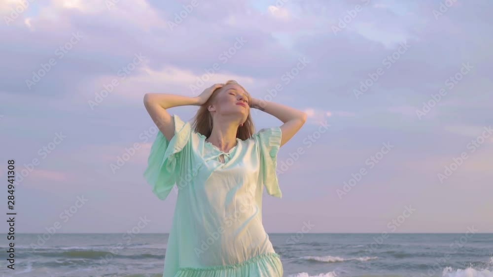Portrait of young woman with red hair standing at the beach close up. Cute girl spends time near the sea. Portrait of young woman with red hair standing at the beach close up. Cute girl spends time near the sea.