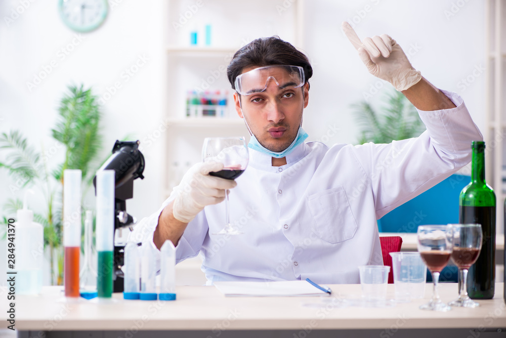 Male chemist examining wine samples at lab Male chemist examining wine samples at lab