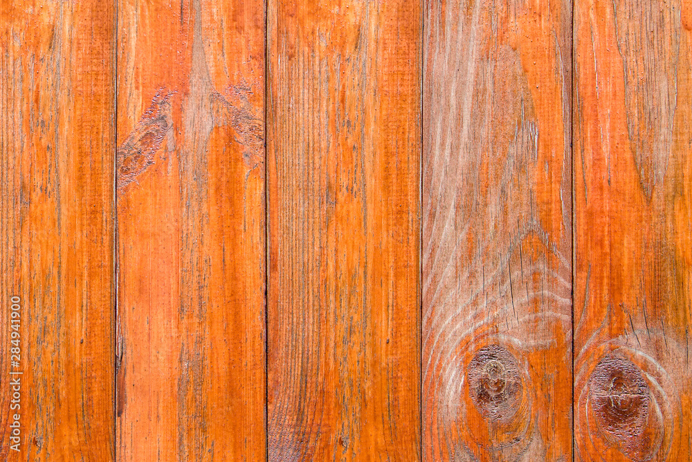 Naklejka premium Old wooden boards with peeling paint. Wooden fence. Grunge style. Orange paint.