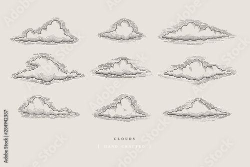 Set of graphically hand drawn clouds on light background. Clouds of various shapes in retro engraving style. Vector vintage illustration.