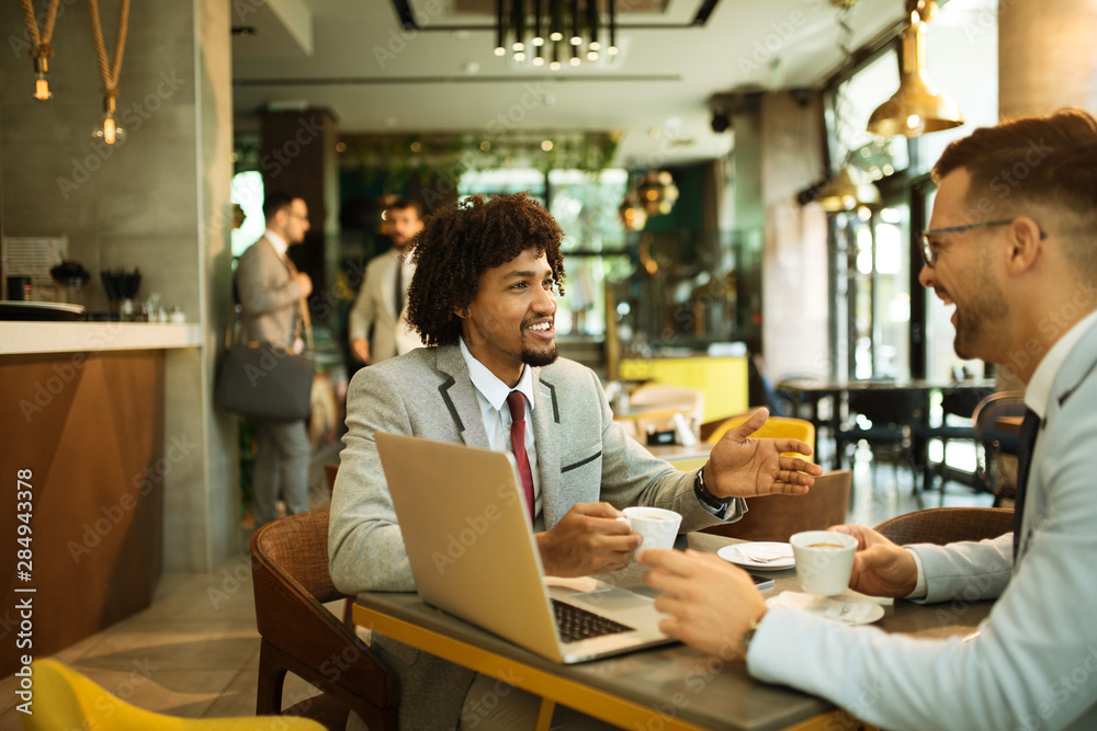 Men are sitting at table in modern cafe. Talk about work Men are sitting at table in modern cafe. Talk about work