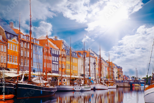 Summer morning view of Nyhavn pier with color buildings, ships, yachts and other boats in the old part of town of Copenhagen, Denmark