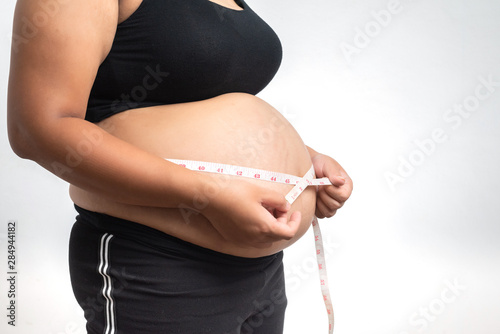 Closeup of Asian pregnant woman Is using a belly scale isolated on white background.