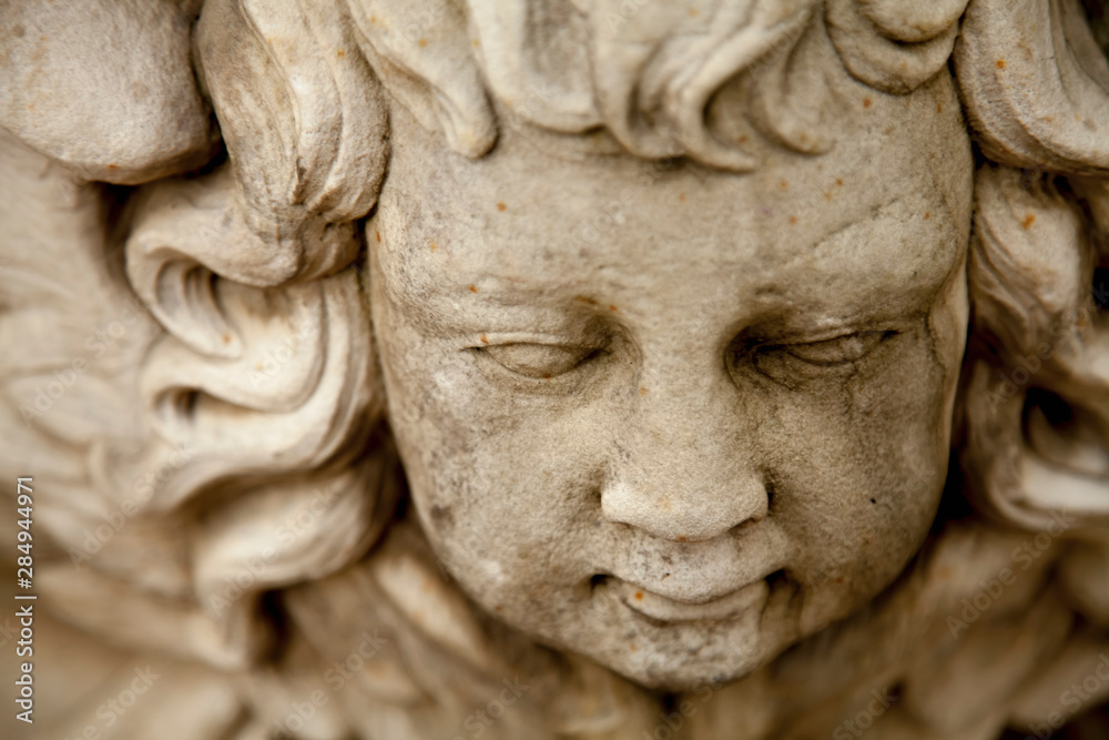 Top view of ancient statue of angel with wings. Selective focus.