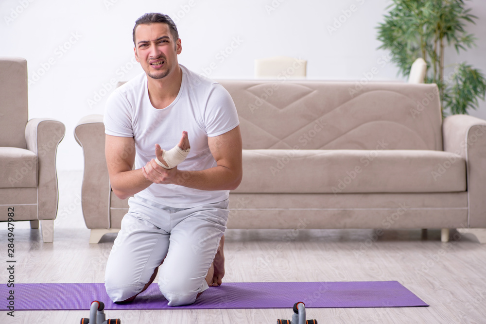 Fototapeta premium Hand injured man doing exercises at home