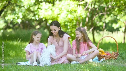 Happy mother and little daughers relax by the lake photo