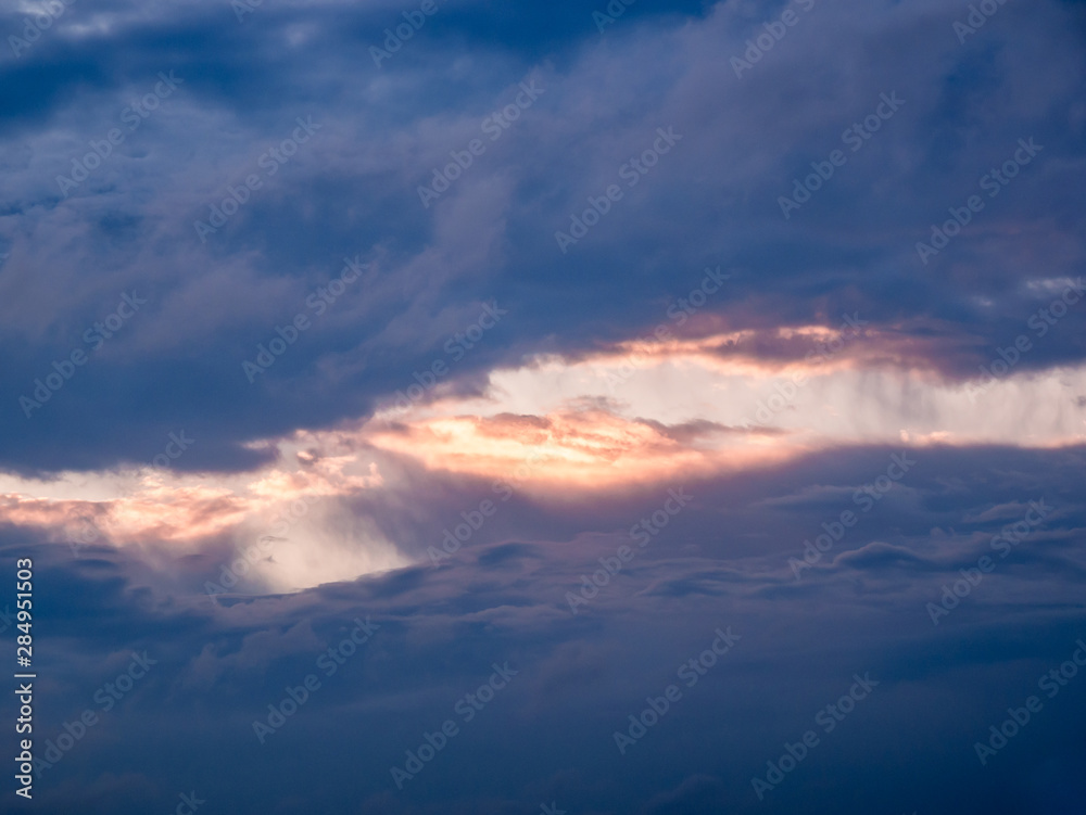 Clouds surrounding a bright rift in the sky at sunrise
