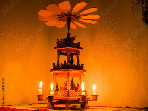 Christmas pyramid with lit candles - warm air from candles spinning propeller on top