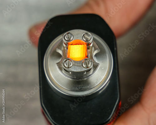 Brightly glowing coil in the atomizer for vaping. photo