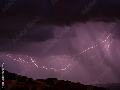 Storm with lightning over hilly landscape - Long exposure at night