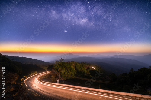 Fototapeta Naklejka Na Ścianę i Meble -  Milky Way Galaxy with lighting on the road and layer of mountain at Doi inthanon Chiang mai, Thailand