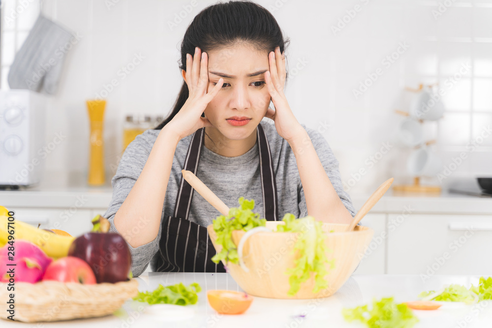 Young woman or housewife is bored of cooking, which consists of a variety of fruits and vegetables for the family.