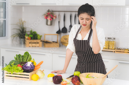 Young woman or housewife is tired of cooking, which consists of a variety of fruits and vegetables for the family.