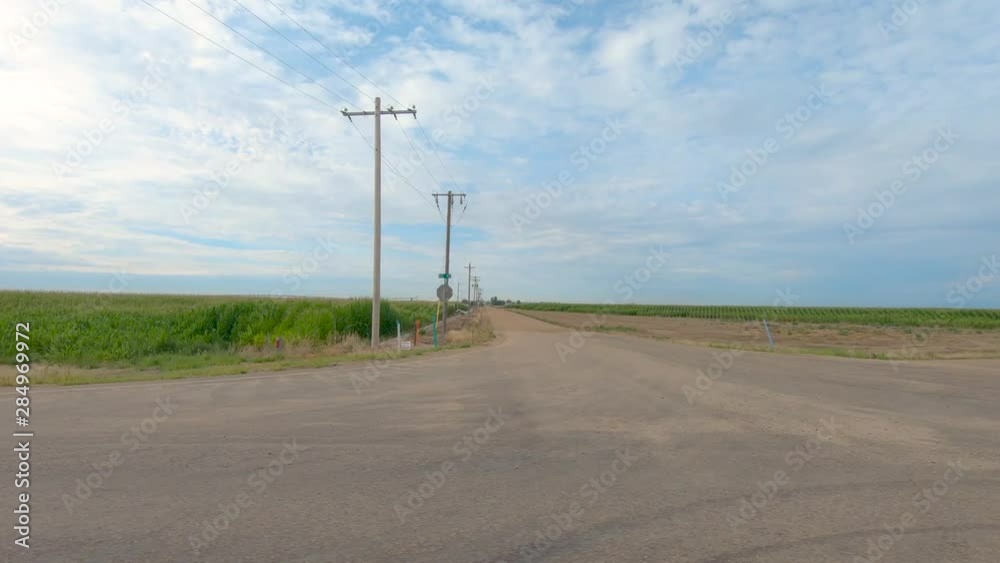 American flags are perched on top of fence posts on this farm house.
