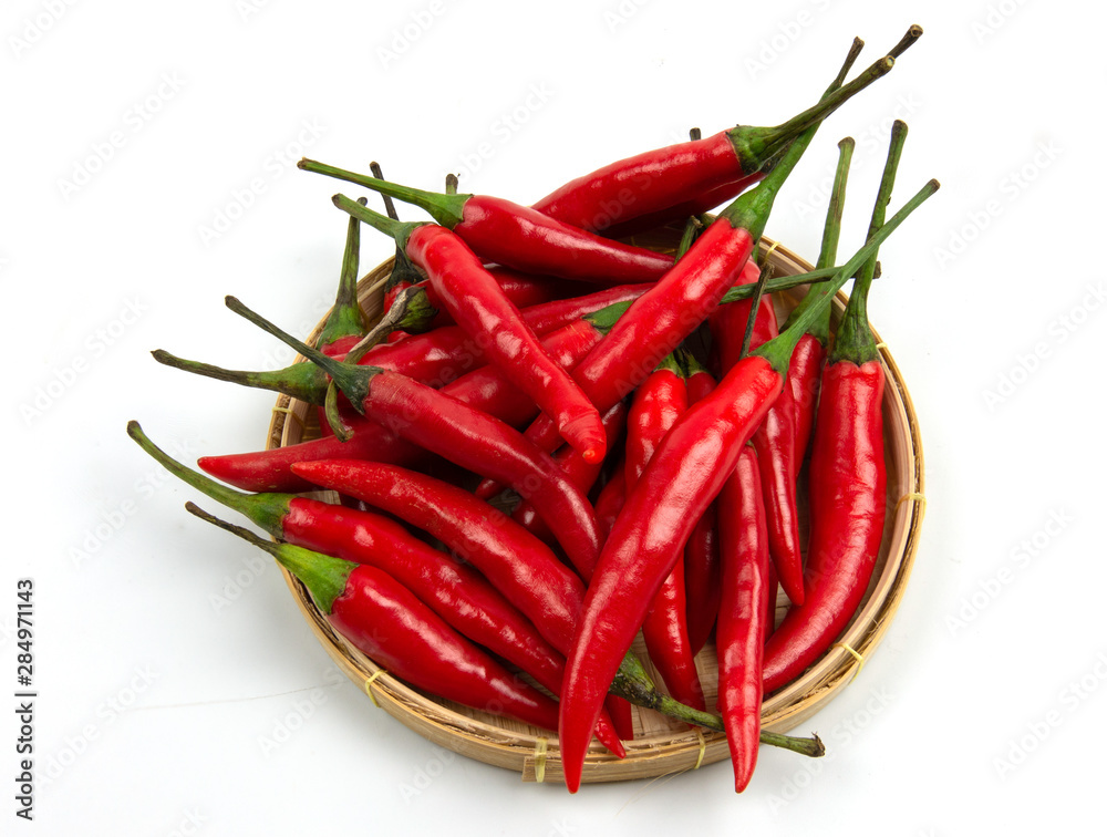 isolated red chilli peppers pile on  threshing basket  on white background