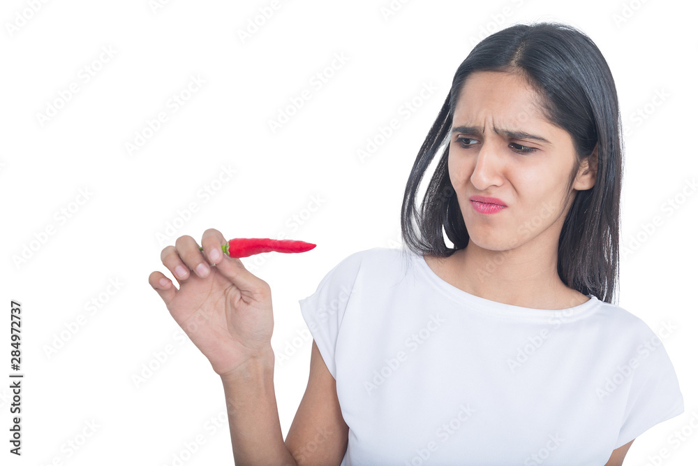 Beautiful girl don't want to eat red pepper chilli isolated on white background Beautiful girl don't want to eat red pepper chilli isolated on white background