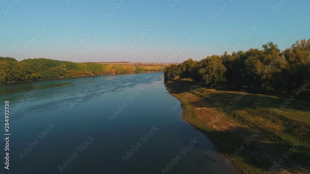 A river with lines of colorful trees on both it's coasts. A river with lines of colorful trees on both it's coasts.