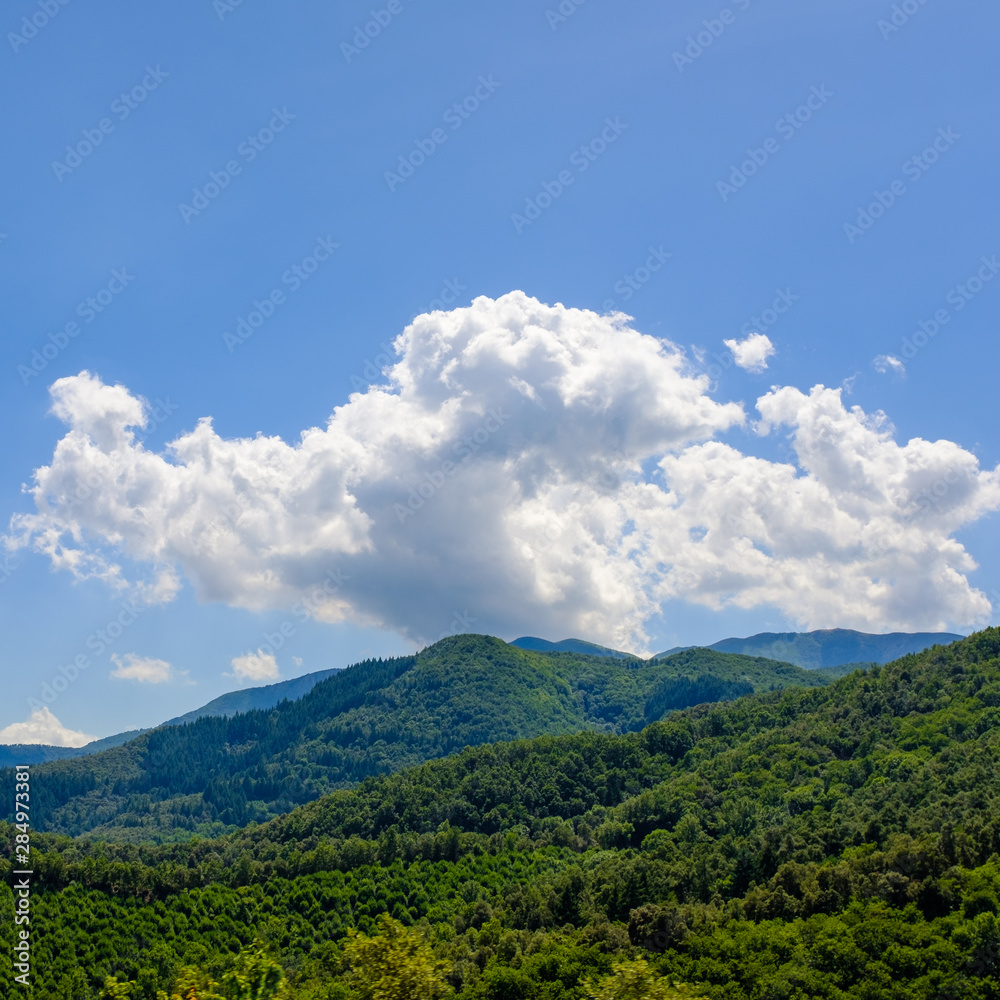 Mountain landscape with lonely clouds on a blue sky