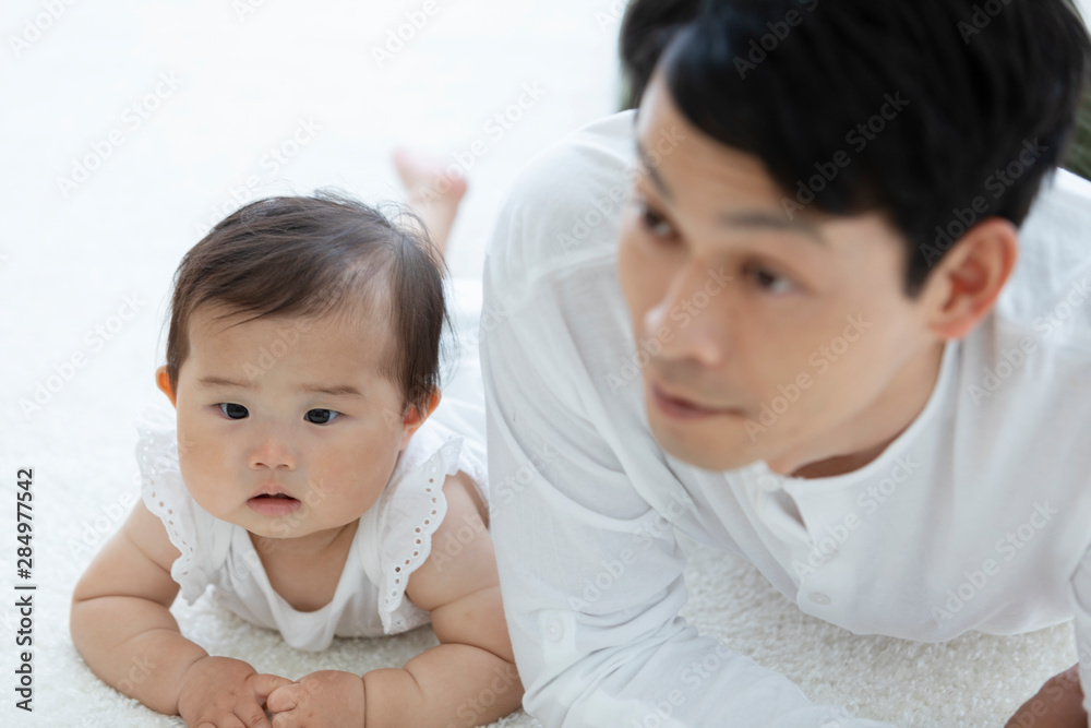 寝転ぶ父親と赤ちゃん