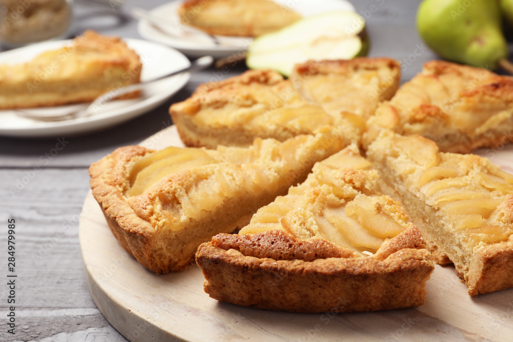 Cut delicious sweet pear tart on wooden table, closeup