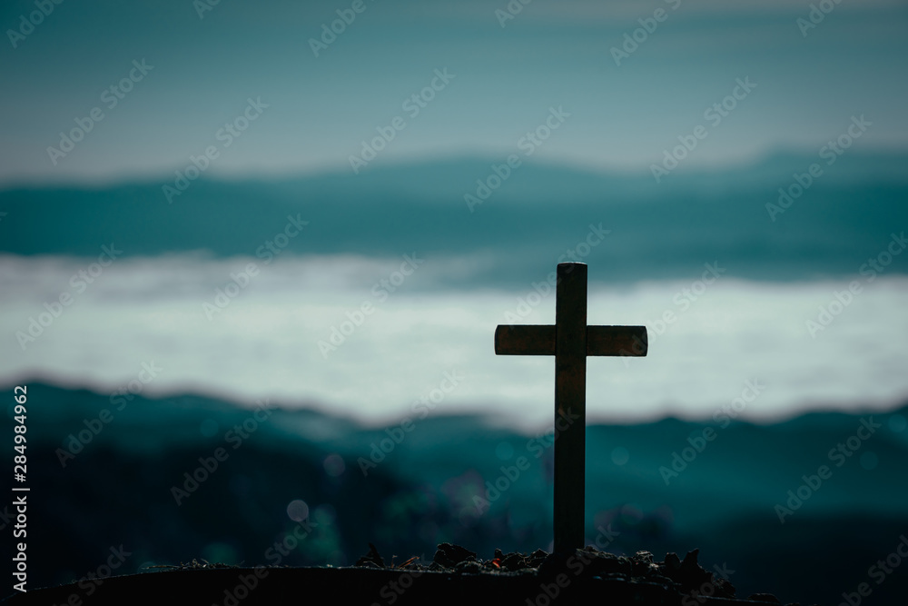 Silhouette of cross on mountain natural background.