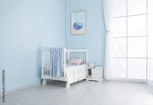 Children's bed in an empty room, lit by sunlight.Cool mat and baby sleeping bag feel comfortable and smooth cloth surface