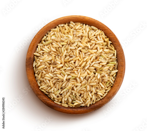 Valokuva Brown rice groats isolated on white background, top view