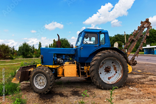 Konstfotografi Soviet, blue tractor with blade and trencher stands on the side of the forest