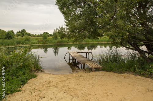 homemade pier on the river or lake  summer landscape in the countryside.