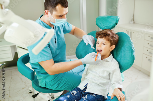 Dentist checks the child's teeth photo