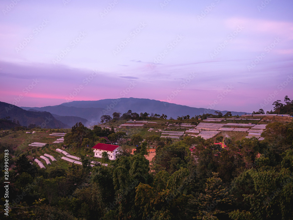 Fototapeta premium Landscape of agricultural areas of people in Fang district, Chiang Mai, Thailand from the top of the mountain in the evening on sunset background.