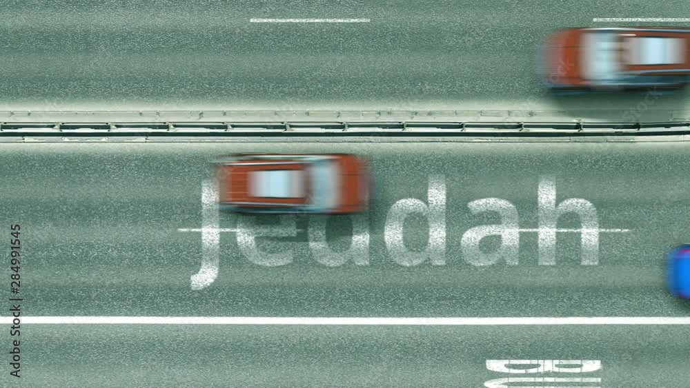Aerial down view of the motorway with cars revealing Jeddah caption. Car travel to Saudi arabia intro clip