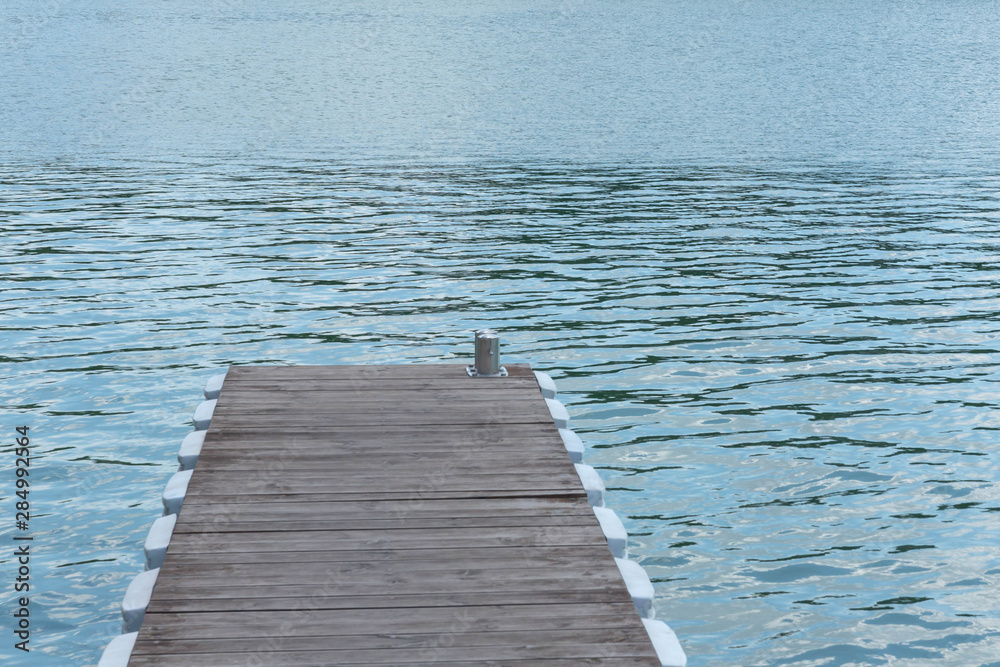 Gray-brown, wooden, pontoon, pier on the water surface of the lake. Gray-brown, wooden, pontoon, pier on the water surface of the lake.