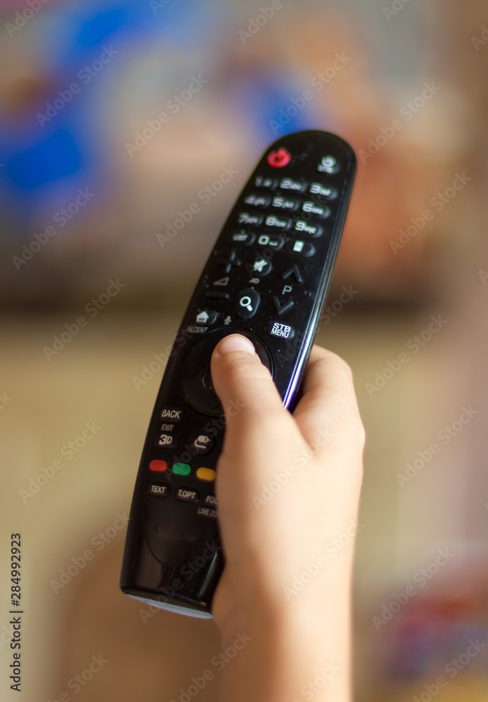 Small boy and TV remote control Small boy and TV remote control
