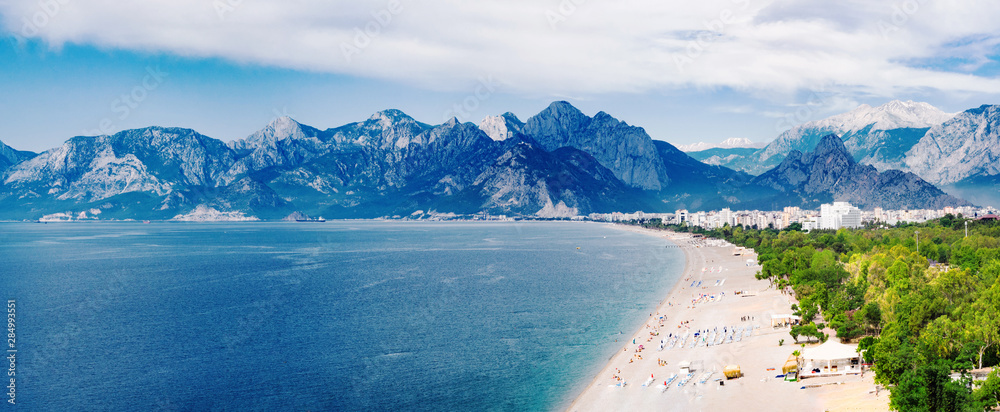 Obraz premium Panoramiczny widok na plażę Konyaalti i Morze Śródziemne na tle gór w Antalya, Turcja