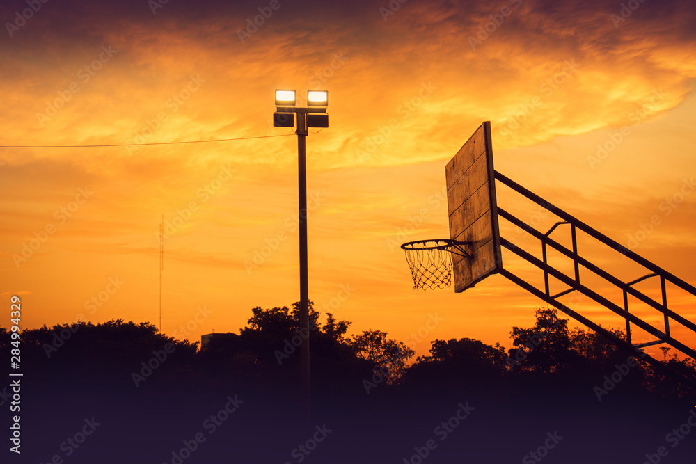 silhouette of outdoor basketball court with dramatic sky in the sunrise morning