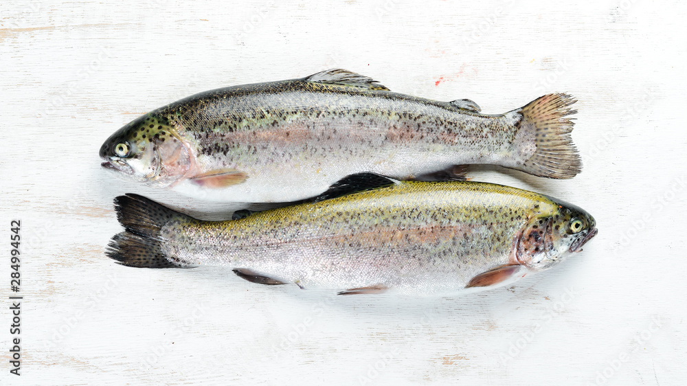 Raw fish trout on a white wooden background. Top view. Free space for your text. Raw fish trout on a white wooden background. Top view. Free space for your text.