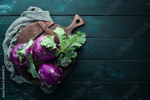 Purple kohlrabi cabbage. On a black background. Top view. Free space for your text. photo