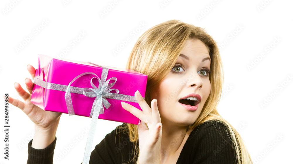 Curious woman holding gift box Curious woman holding gift box