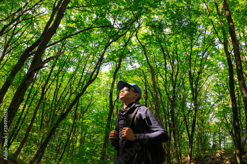 Traveler guy walks through the woods