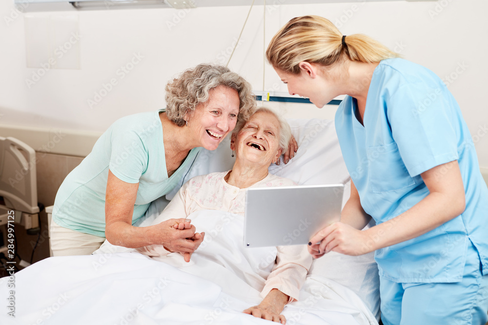 Obraz premium Pflegekraft zeigt Senior Frau einen Tablet PC