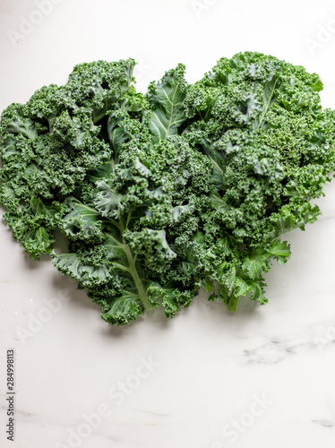 A bunch of green kale on a white marble background