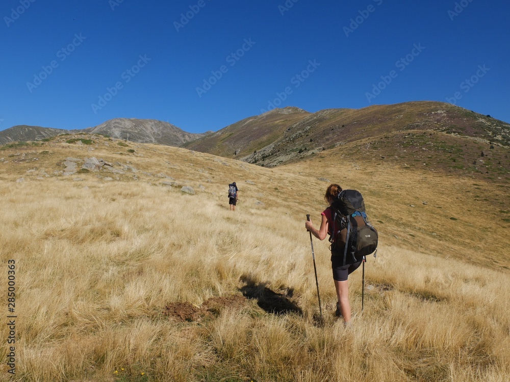Obraz premium Randonneurs homme et femme avec sac à dos en montagne dans les herbes jaunes