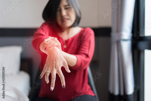 Woman suffering with parkinson's disease symptoms,Selective focus hands photo