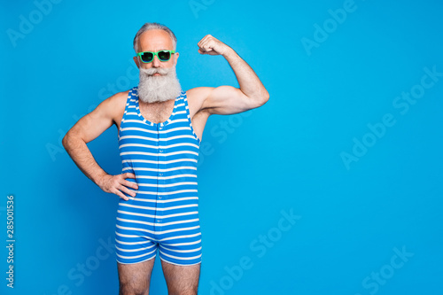 Portrait of his he nice attractive content cool sportive gray-haired man trainer instructor showing power isolated over bright vivid shine turquoise blue green background photo