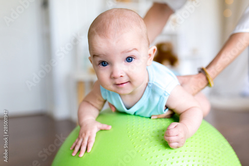 Exercise with a child on the ball. Professional baby massage at home.