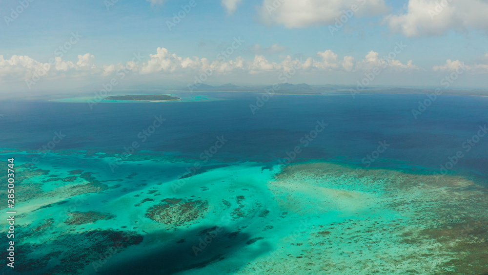 Tropical islands with coral reefs in the blue water of the sea, aerial view. Balabac, Palawan, Philippines. Summer and travel vacation concept.