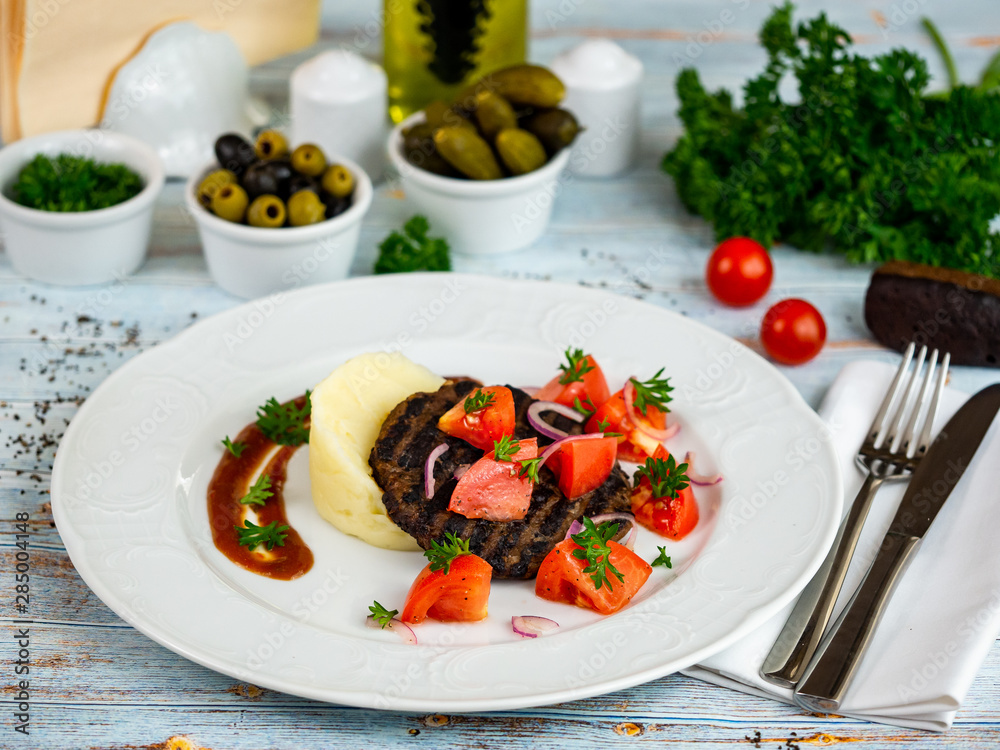 Meat cutlet with mashed potatoes and tomatoes. Restaurant serving. Meat cutlet with mashed potatoes and tomatoes. Restaurant serving.