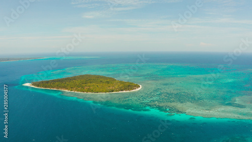 Tropical island with sandy beach by atoll with coral reef and blue sea, aerial view. Patongong Island with sandy beach. Summer and travel vacation concept.