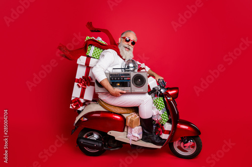 Profile side view of his he nice attractive cheerful cheery funky bearded gray-haired father delivering carrying desirable purchase discotheque isolated on bright vivid shine red background